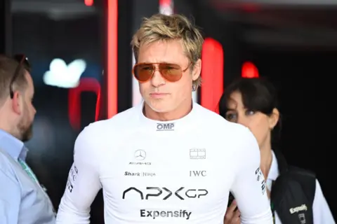 Getty Images Picture of Brad Pitt in a white racing suit wearing sunglasses.