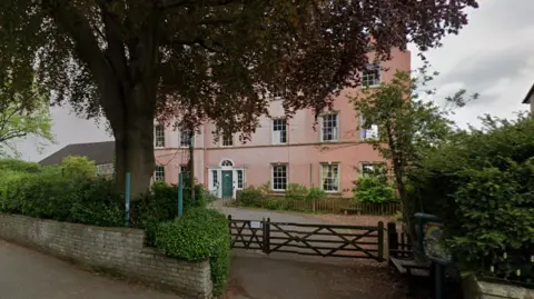 Google Maps Entrance to pink-coloured school with trees around