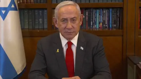 Office of Israeli Prime Minister Netanyahu looks at the screen as he addresses the Israeli nation.