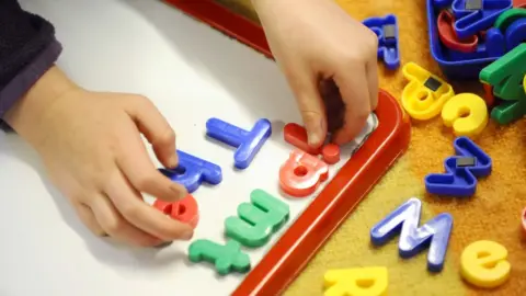 PA Child playing with plastic letters