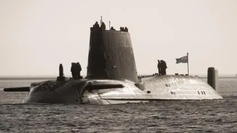 Ministry of Defence A file photo from 2009 shows HMS Astute in a body of water - troops stand on top of the vessel and a flag flies in the wind.