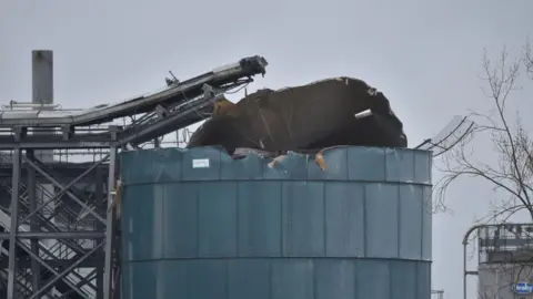 A water treatment plant is pictured with its roof blown off and damaged structure.