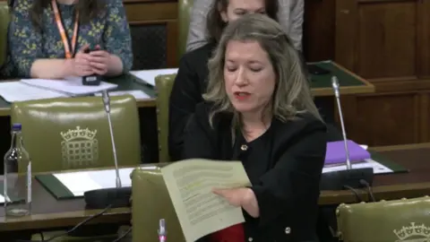 UK Parliament Marie Tidball holding a piece of paper in Parliament