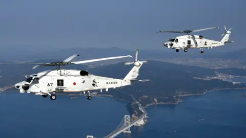 JAPAN MARITIME SELF-DEFENSE FORCE Two Japanese navy SH-60k helicopters flying over Japanese waters
