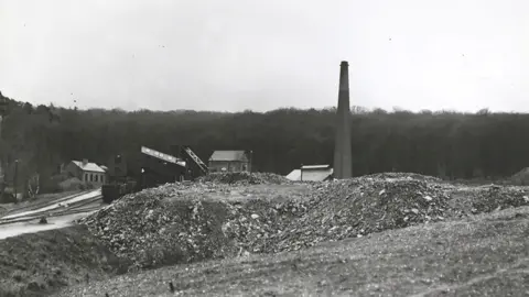 Getty Images Black and white image of Brereton Colliery taken in 1908. Behind spoil heaps in the foreground are the colliery buildings, including a large chimney to the right