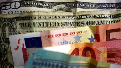 Reuters Dollar bills and euro notes