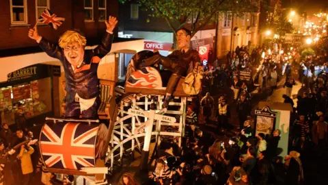 Getty Images/Peter Summers A Brexit rollercoaster featuring the Prime Minister, and Jacob Rees-Mogg lounging on one of the carriages.