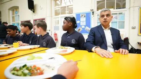 PA Media Sadiq Khan at table with school children