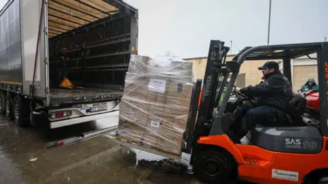 A forklift truck loads aid into a lorry