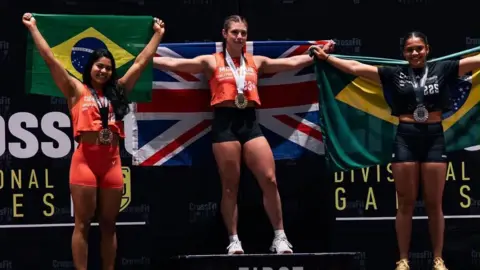 @inov8 A girl standing on a podium with medals around her neck, is holding a large union jack flag.
