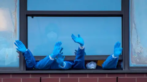 Getty Images Staff wave out of the Royal Gwent Hospital window