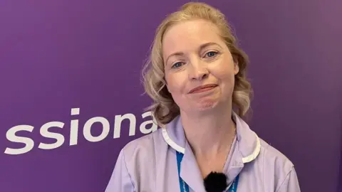 Chrsitina Hill, social carer for Devon Home Care Limited standing in front of a purple wall
