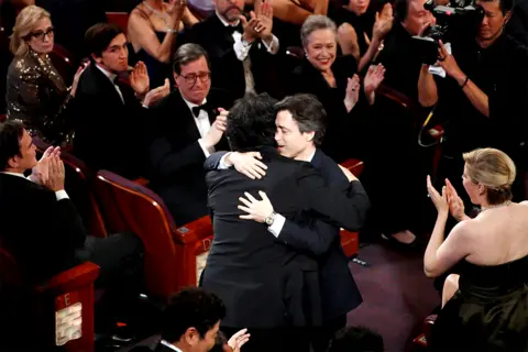 Reuters Director Bong Joon-ho receives a hug from Noah Baumbach