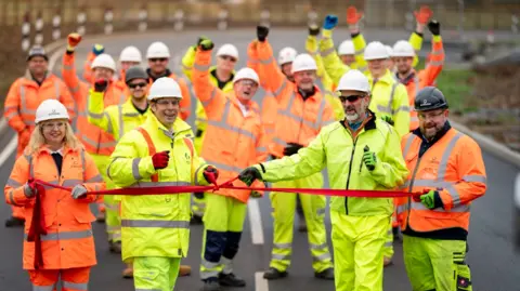 Somerset Town Hall Image of councilors and hired team cutting a red ribbon along the new road 