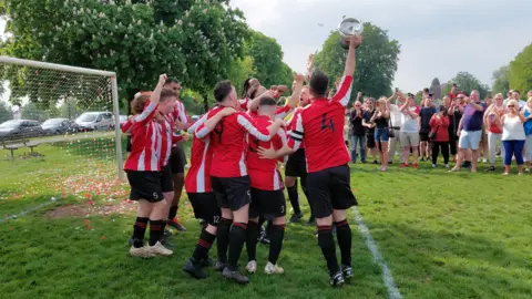 The Bristol Old Saints celebrating at a match on the Downs in Bristol in front of fans