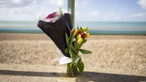 Eddie Mitchell A floral tribute is laid on a beach. 