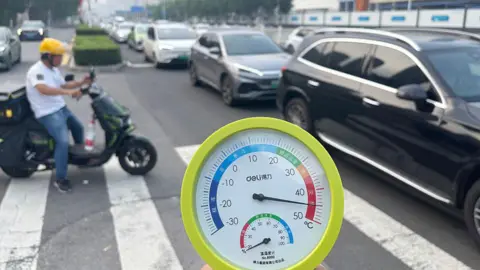 Getty Images Close-up of a thermometer showing the temperature of the air exceeding 40 degrees Celsius. Behind it is a busy road with cars and a motorcycle.