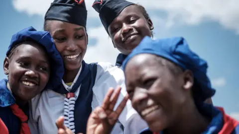 AFP Members of Kenya Girl Guides take photos after attending ceremony of the International Women"s day at Kawangware in Nairobi, Kenya, on March 8, 2018