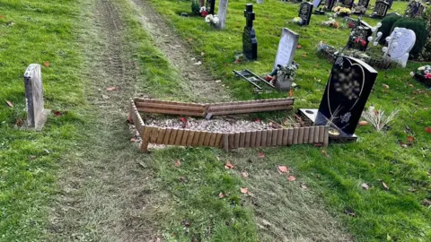 Alastair Chambers A grave with digger tracks going over it