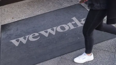 Getty Images Person walks past WeWork entrance