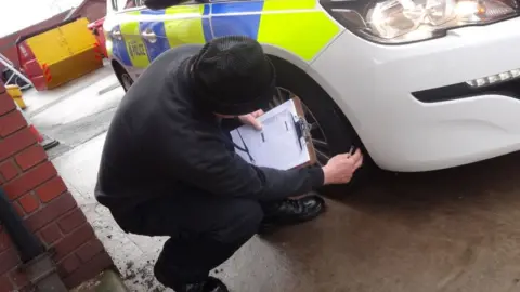 South Yorkshire Police Volunteer checks police car