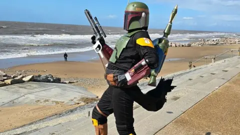 Neil Trickett A trooper from one of the Star Wars franchise shows with a full helmet, gun and rocket launcher stands on Cleveleys beach.