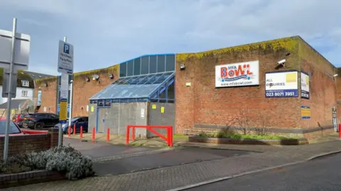 Dorset Council A general view of the outside of the bowling alley, which is evidently worn and has moss or some sort of growth at the top edge of the building