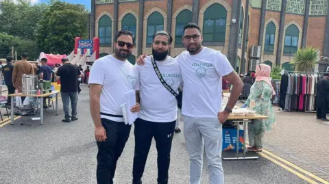 Shafeel Hussain Shafeel Hussain with volunteers Abrar Ahmed and Shaz Khansmiling for camera 