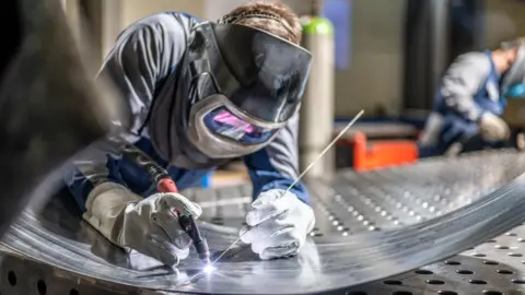 Getty Images Person in factory welding metal wearing protective equipment
