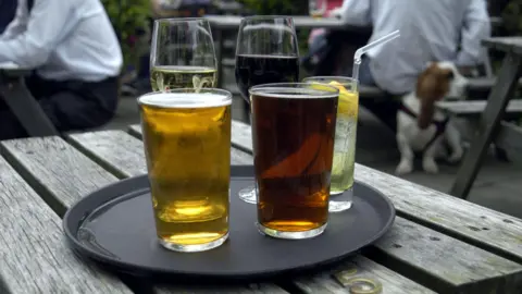 BBC Una bandeja de bebidas en una mesa al aire libre, con cerveza, vino y algunos refrescos.