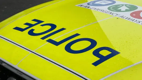 A yellow high-vis police car bonnet, with reverse lettering reading "police".