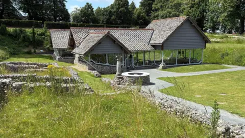 The Roman Town House site. The main part of the site has a modern covering. Low stone walls presumably delineate the layout of the old site.