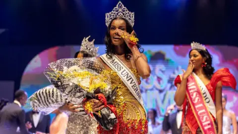 Benson Ibeabuchi / AFP Chidimma Adetshina, pemenang Miss Universe Nigeria, memegang buket bunga dan mengenakan mahkota besar di Lagos, Nigeria - Sabtu 31 Agustus 2024