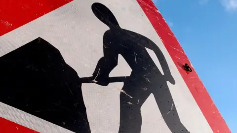 Getty Images A roadworks sign with a red triangle around a silhouette of a workman and a shovel