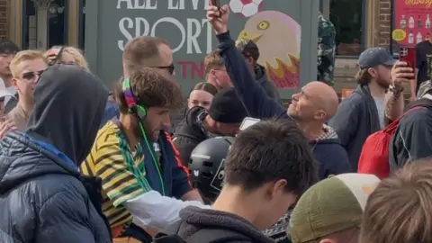 Alex Harding Dom Whiting in Oxford on one of his bike raves, surrounded by people riding bikes. Some are taking images.
