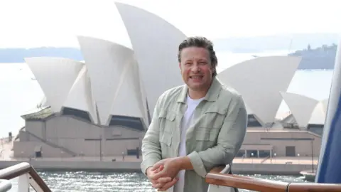 Getty Images Jamie Oliver stands in front of the Sydney Opera House