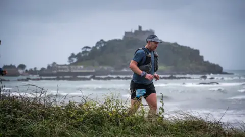 An image of someone running in front of St Michael's Mount.