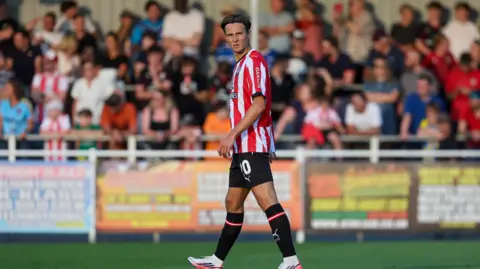 Caspar Jander playing football in his red and white striped Southampton kit during a pre-season friendly against Eastleigh