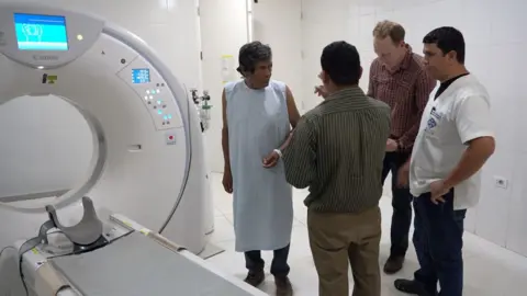 CT scanner with a group of people next to it