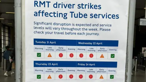 A poster at a tube station titled "RMT driver strikes affecting Tube services" detailing significant travel disruption. It features a colour-coded calendar for Tuesday 21 April through Friday 24 April, indicating service levels across morning, afternoon, and evening time slots using green ticks, yellow caution triangles, and red exclamation marks.