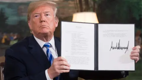 AFP/Getty US President Donald Trump holding an order withdrawing the US from an landmark nuclear deal with Iran