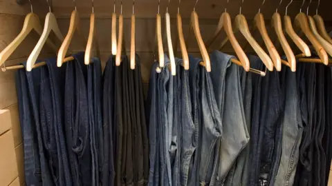 Getty Images Rows of jeans in a wardrobe