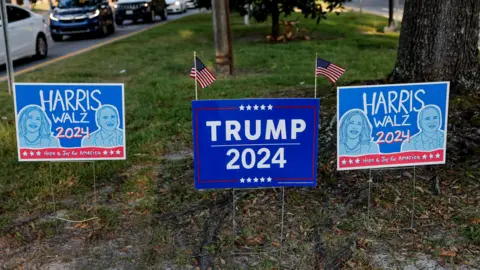 EPA-EFE Competing Trump/Harris campaign signs on a lawn in Savannah, Georgia