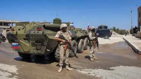 AFP Russian soldiers stand by an armoured personnel carrier in the Deraa al-Balad area of Deraa city, Syria, on 6 September 2021