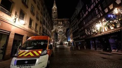 EPA Rescue vehicles are parked near the Christmas market near the site of the deadly shooting in Strasbourg on 12 December 2018