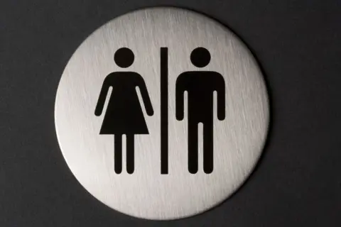 Getty Images A sign for men's and women's toilets, black outlines on a silver background