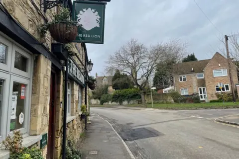 The filled in tarmac from further back, the Red Lion pub visible on the left.