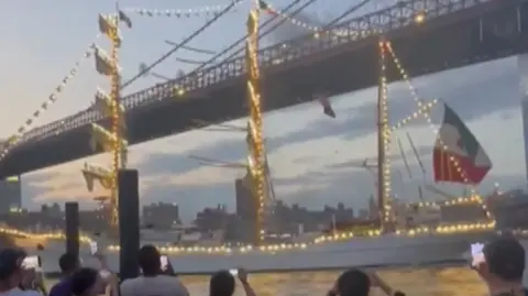 Naval ship in front of Brooklyn Bridge 