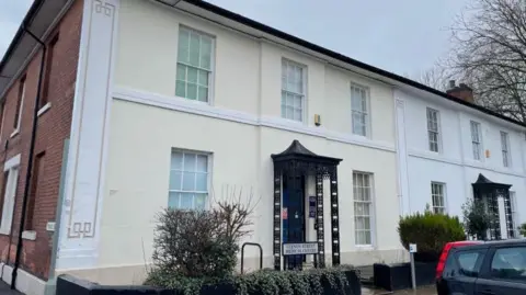 The exterior of Vernon Street Medical Centre, a white two-storey building with a dark blue door.