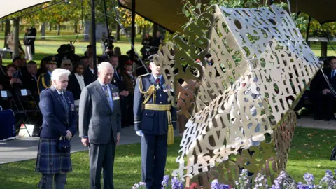 Peter Byrne/PA Wire King Charles II stands between two veterans next to a steel memorial that was unveiled at the arboretum last year.